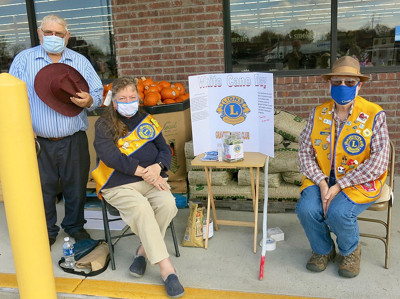 Westside Eagle Observer/SUSAN HOLLAND
Members of the Gravette Lions Club pause for a photo during their annual White Cane Day event Saturday, Nov. 7. Over $115 was raised at this year's fundraiser and proceeds will be used to help fund an eye exam and glasses for a needy individual. Pictured are club tail twister Bill Mattler, club president Linda Damron and club treasurer Jeff Davis.