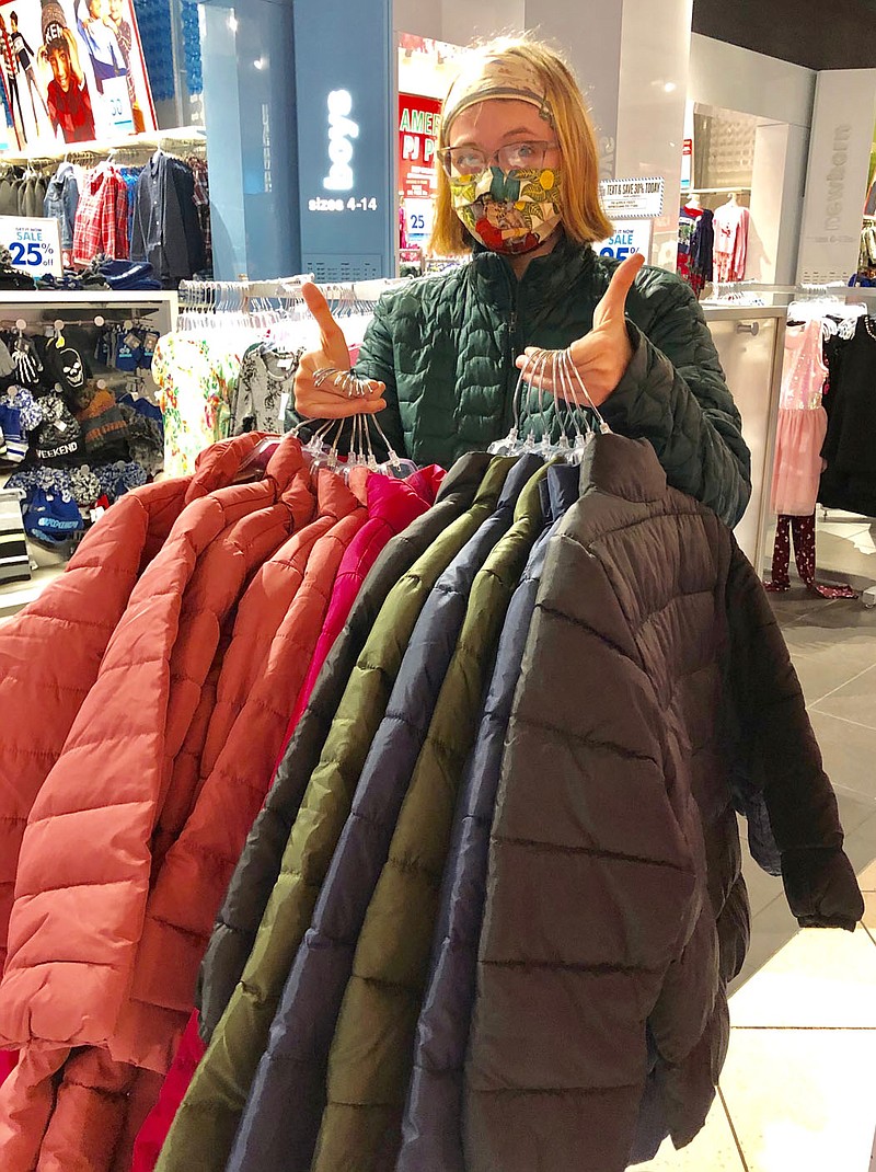 Submitted Photo
Alyssa Allen displays some of the many coats recently purchased to distribute in her third annual Give Warmth clothing drive. Allen is a 2019 Gravette High School graduate who works with Bright Futures to ensure that needy students in the school district are supplied with warm clothing for the winter.