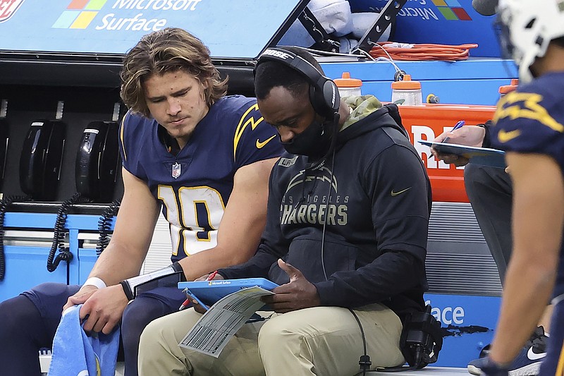 Los Angeles Chargers quarterback Justin Herbert (10) gets instruction from quarterbacks coach Pep Hamilton during an NFL football game against the Las Vegas Raiders, Sunday, Nov. 8, 2020, in Inglewood, Calif. The most recognizable trend in hiring NFL head coaches has been to target young, innovative offensive teachers with a track record of developing quarterbacks. (AP Photo/Peter Joneleit)