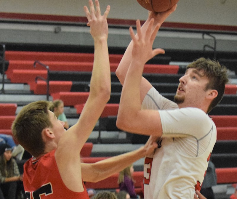 RICK PECK/SPECIAL TO MCDONALD COUNTY PRESS Teddy Reedybacon shoots over Eli McClain during the McDonald County Mustangs scrimmage on Nov. 13 at MCHS.