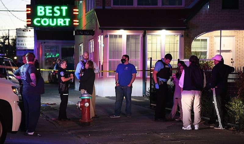 Hot Springs police officers interview witnesses to a fatal shooting that occurred at around 5 p.m. Tuesday near the Best Court Motel, 638 Ouachita. - Photo by Grace Brown of The Sentinel-Record