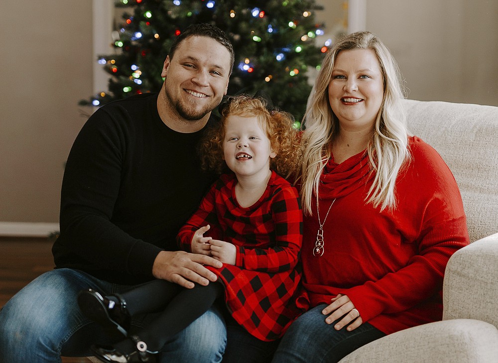Nick Jones, left, poses with his wife Mindy Jones and their daughter Gracelyn Jones at their home in Louisville, Ky. The Jones family are among a growing number of people who have gone full-on Christmas weeks early. Usually Mindy waits until the Saturday after Thanksgiving to jump start the holiday. (Jade Ware via AP)