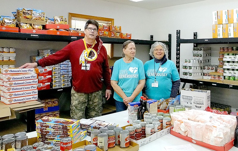 Lynn Atkins/The Weekly Vista 
John Peshek, Elaine Sherman and Diana Wickbolt pose in the Shepard's Food Pantry located in the Bella Vista Lutheran Church.  In November, clients receive a turkey breast, stuffing and vegetables in addition to the regular food bag. The pantry is open on Friday mornings.
