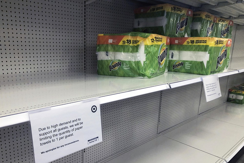 The quantity of paper towels customers can buy is listed at a Target Store, Tuesday, Nov. 17, 2020, in Bloomington, Minn. A surge of new coronavirus cases in the U.S. is sending people back to stores to stockpile again, leaving shelves bare and forcing retailers to put limits on purchases. (AP Photo/Jim Mone)