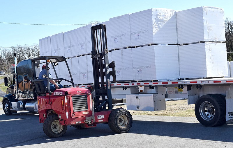 Westside Eagle Observer/MIKE ECKELS

A forklift unloads pallets full of  building material from a flatbed truck Nov. 16 in the parking lot near Peterson Gym in Decatur. The material will be used in the construction of the new high school cafeteria and renovation of the existing DHS facility.