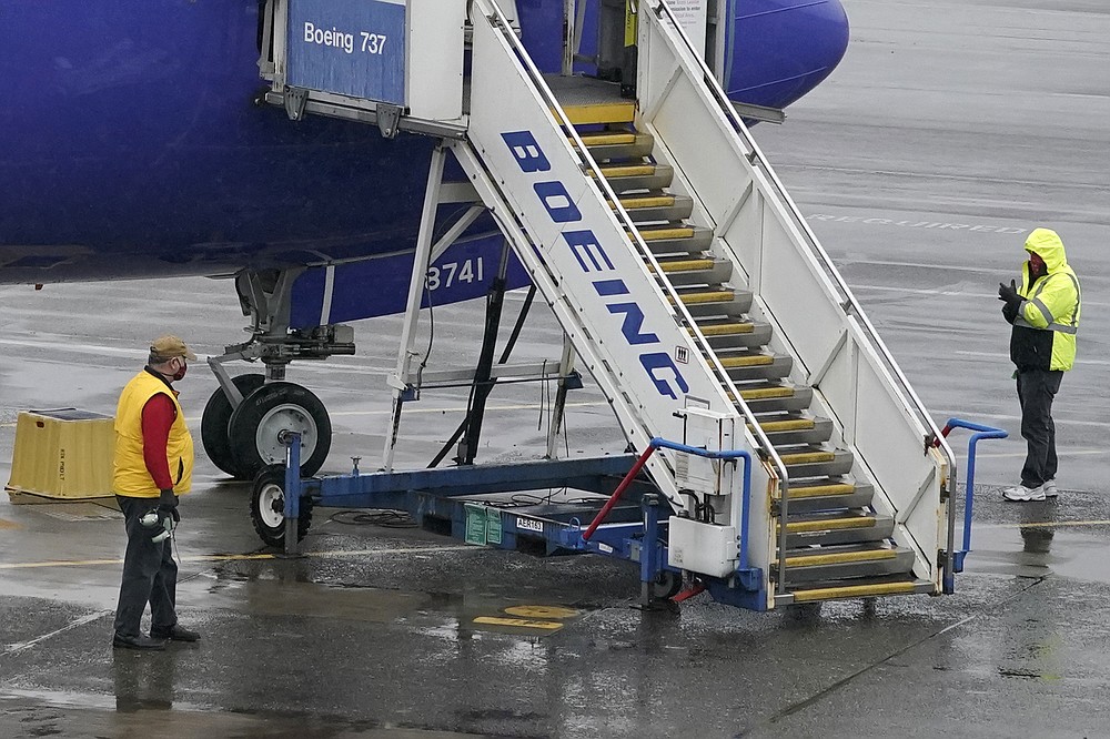 Workers walk near a Boeing 737 Max 8 built for Southwest Airlines at Renton Municipal Airport, Wednesday, Nov. 18, 2020, in Renton, Wash. After nearly two years and a pair of deadly crashes, the U.S. Federal Aviation Administration announced Wednesday that the 737 Max has been cleared for flight after regulators around the world grounded the Max in March 2019, after the crash of an Ethiopian Airlines jet. (AP Photo/Ted S. Warren)