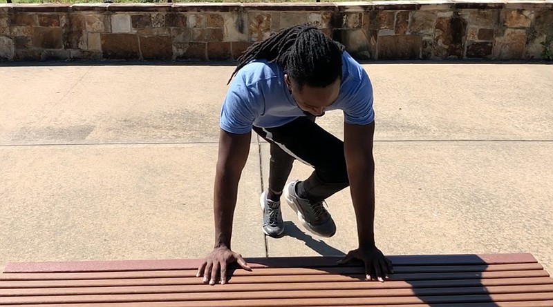 Emmanuel Eyiuche does step 2 of the Incline Plank Twist on a bench near the Little Rock ramp of Two Rivers Park Bridge.  (Arkansas Democrat-Gazette/Celia Storey)