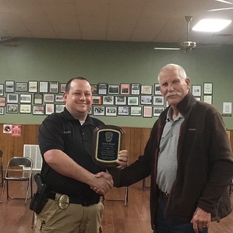 Elm Springs Police Chief Jason Hiatt recently celebrated 20 years service as an officer and police chief. He was presented with a plaque to commemorate his loyalty and dedicated service at the Council meeting on Nov. 19. Chief Hiatt received the 20-year service plaque from Mayor Harold Douthit.

(Courtesy Photo)