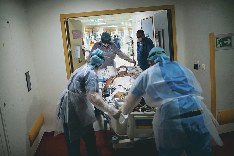 A 60-year-old COVID-19 patient is transferred to the main ICU at the La Timone hospital in Marseille, southern France, from a makeshift wing which could not support both the dialysis and respirator machines necessary for his worsening condition on Thursday, Nov. 12, 2020. France is more than two weeks into its second coronavirus lockdown, and intensive care wards have been over 95% capacity for more than 10 days now. Marseille has been submerged with coronavirus cases since September. The port city, on France's Mediterranean coast, was spared the worst of the virus last spring only to be hit with a vengeance as the summer vacation wound down. (AP Photo/Daniel Cole)
