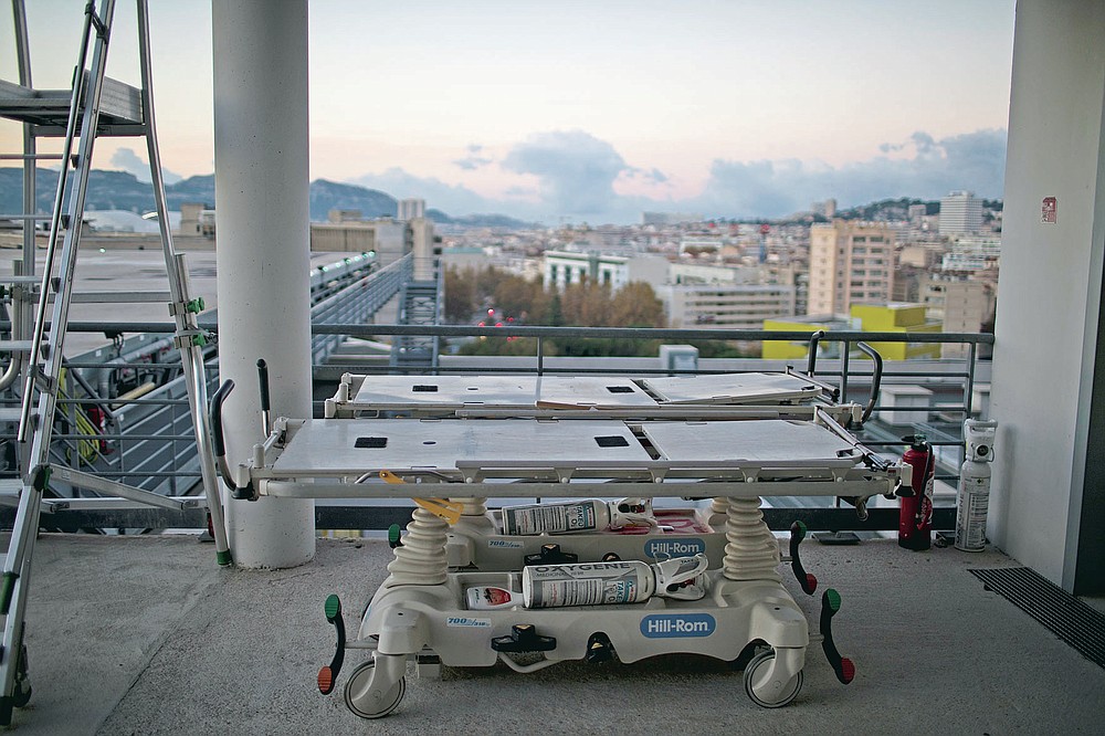 Portable intensive care beds with oxygen tanks are pictured on the rooftop of the La Timone hospital as the sun rises in Marseille, southern France, Friday, Nov. 13, 2020. France is more than two weeks into its second coronavirus lockdown, and intensive care wards have been over 95% capacity for more than 10 days now. Marseille has been submerged with coronavirus cases since September. (AP Photo/Daniel Cole)