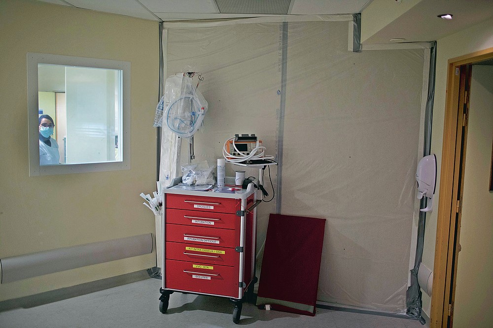 A fiberboard barricade fastened to a hospital corridor with duct tape seals off an acute care wing that was only recently refashioned into a makeshift COVID-19 ICU ward at the La Timone hospital in Marseille, southern France, Thursday, Nov. 12, 2020. (AP Photo/Daniel Cole)