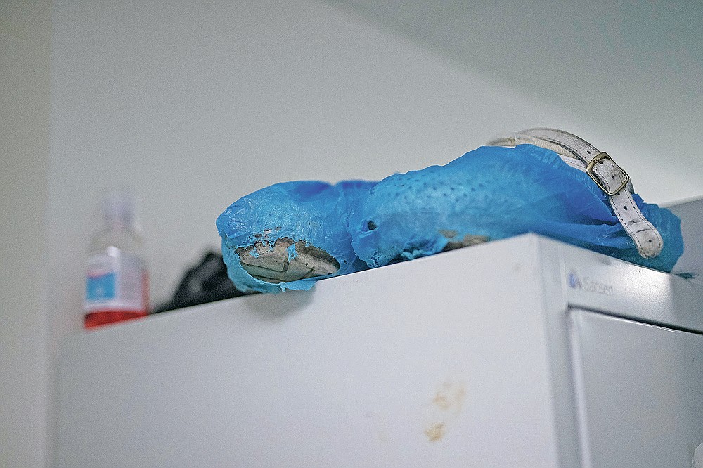 Worn fibre shoe covers are pictured in the nurse's COVID-19 ICU locker room at the La Timone hospital in Marseille, southern France, Thursday, Nov. 12, 2020. France is more than two weeks into its second coronavirus lockdown, and intensive care wards have been over 95% capacity for more than 10 days now. Marseille has been submerged with coronavirus cases since September. (AP Photo/Daniel Cole)