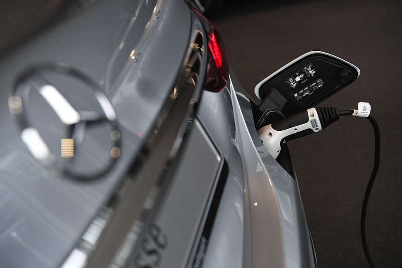 An electric charging plug refuels a Mercedes-Benz AG E-Class electric automobile at the automaker's showroom, operated by Daimler, in Boeblingen, Germany, on Sept. 29, 2020. MUST CREDIT: Bloomberg photo by Andreas Gebert.