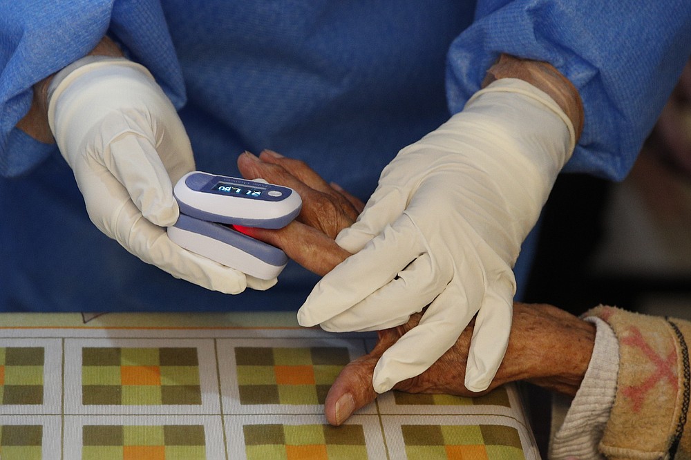Carmen Rosas, 93, has her blood oxygen checked before being tested for COVID-19, in her home in the Venustiano Carranza borough of Mexico City, Thursday, Nov. 19, 2020. (AP Photo/Rebecca Blackwell)