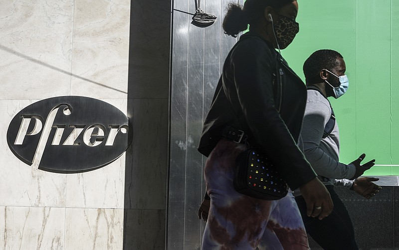 In this Nov. 9 file photo, pedestrians walk past Pfizer world headquarters in New York. - AP Photo/Bebeto Matthews, File