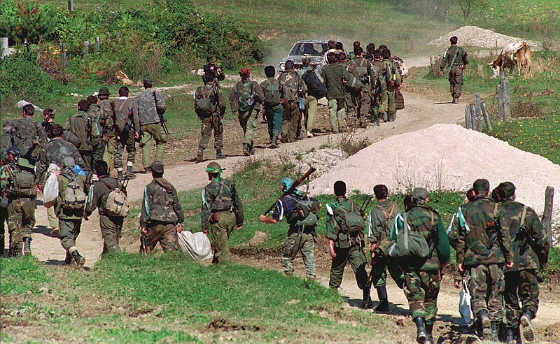 FILE - In this Sept. 28, 1995. file photo, a line of Bosnian government troops makes its way to the front-line near Mrkonjic Grad 120kms (80mls) north west of Sarajevo, Bosnia. While it brought an end to the fighting, the Dayton peace agreement baked in the ethnic divisions, establishing a complicated and fragmented state structure with two semi-autonomous entities, Serb-run Republika Srpska and a Federation shared by Bosniak and Croats, linked by weak joint institutions. (AP Photo/Darko Bandic, File) story.lead_photo.caption