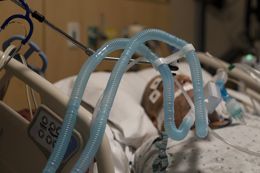 FILE - In this Nov. 19, 2020, file photo, ventilator tubes are attached to a COVID-19 patient at Providence Holy Cross Medical Center in the Mission Hills section of Los Angeles. The surge of coronavirus is taking an increasingly grim toll across the United States, even as of a vaccine appears close at hand. (AP Photo/Jae C. Hong, File)