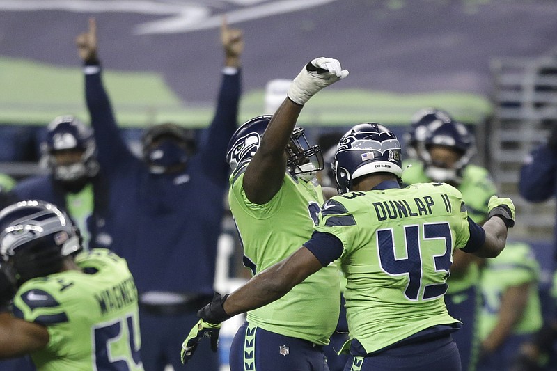 Seattle Seahawks defensive end Carlos Dunlap (43) celebrates with defensive end L.J. Collier, center-left, after Dunlap sacked Arizona Cardinals quarterback Kyler Murray late in the second half of an NFL football game, Thursday, Nov. 19, 2020, in Seattle. The Seahawks won 28-21. (AP Photo/Lindsey Wasson) story.lead_photo.caption