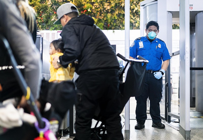 A Transportation Security Administration officer wears a protective face mask while working his shift at Terminal B at Oakland International Airport in Oakland, Calif., on March 4. MUST CREDIT: Washington Post photo by Melina Mara.
