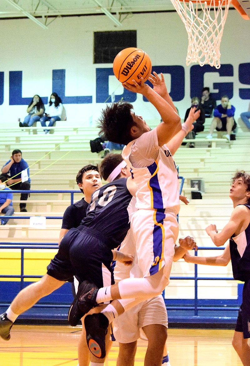 Westside Eagle Observer/MIKE ECKELS

Christian Ramirez (center) flies through the air on his way to the basket for a layup during the Decatur-Haas Hall Rogers non-conference varsity ball game at Peterson Gym in Decatur Friday night.