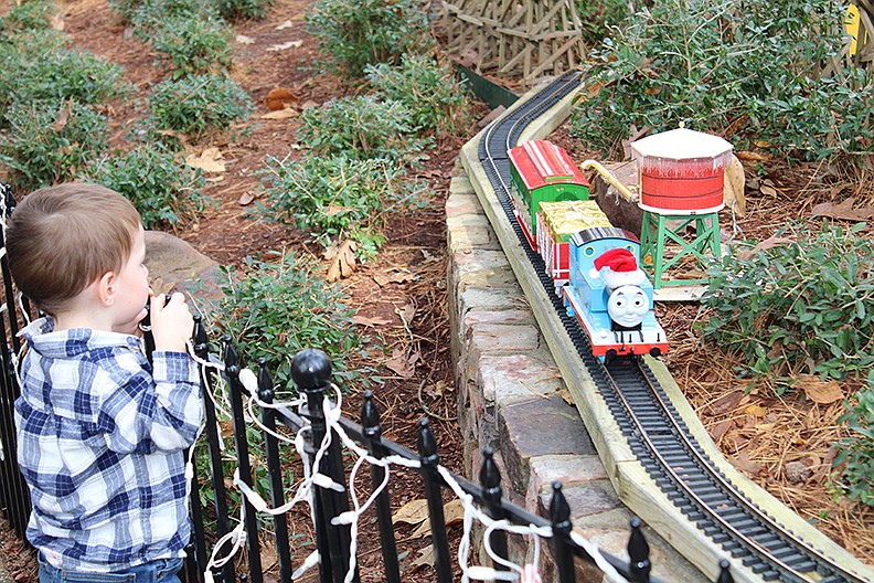Liam Owens, of Conway, watches as a festive Thomas the Tank Engine goes by at Garvan Woodland Gardens on Saturday during the opening of its Winter Garden Festival. The new daytime festival, which features displays throughout the botanical garden, is a pandemic alternative to Garvan’s popular Holiday Lights event. - Photo by Tanner Newton of The Sentinel-Record story.lead_photo.caption