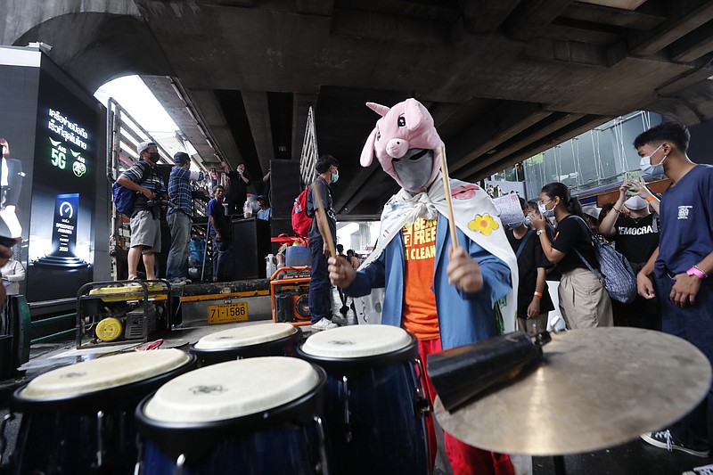 An individual wearing a mask beats conga drums during a student rally in Bangkok, Saturday, Nov. 21, 2020. Organized by a group that mockingly calls themselves "Bad Students," the rally calls for educational reforms and also supports the broader pro-democracy movement's demands for constitutional change. (AP Photo/Sakchai Lalit)