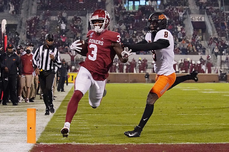 Oklahoma tight end Mikey Henderson (3) carries for a touchdown past Oklahoma State defender Rodarius Williams (8) during the first half of an NCAA college football game in Norman, Okla., Saturday, Nov. 21, 2020. (AP Photo/Sue Ogrocki)