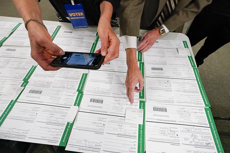 A canvas observer photographs Lehigh County, Pa., provisional ballots as part of vote counting in the general election in Allentown, Pa., in this Nov. 6, 2020, file photo.