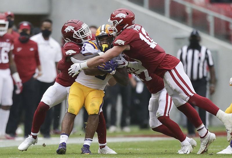 Arkansas defenders tackle LSU running back Tyrion Davis-Price (3) during the third quarter of Saturday's game at Donald W. Reynolds Razorback Stadium in Fayetteville. - Photo by Charlie Kaijo of NWA Democrat-Gazette