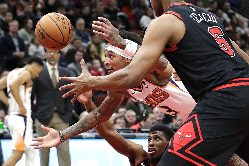 Phoenix Suns forward Kelly Oubre Jr., middle, reaches for the ball between Chicago Bulls forward Thaddeus Young, bottom, and forward/center Cristiano Felicio during the second half of an NBA basketball game in Chicago, Saturday, Feb. 22, 2020. The Suns won 112-104. (AP Photo/Nam Y. Huh)