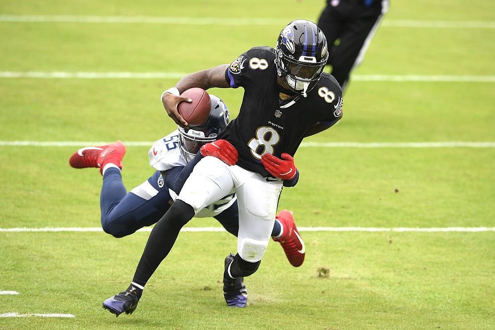Baltimore Ravens quarterback Lamar Jackson (8) runs with the ball while Tennessee Titans inside linebacker Jayon Brown tries to stop him during the first half of an NFL football game, Sunday, Nov. 22, 2020, in Baltimore. (AP Photo/Nick Wass)