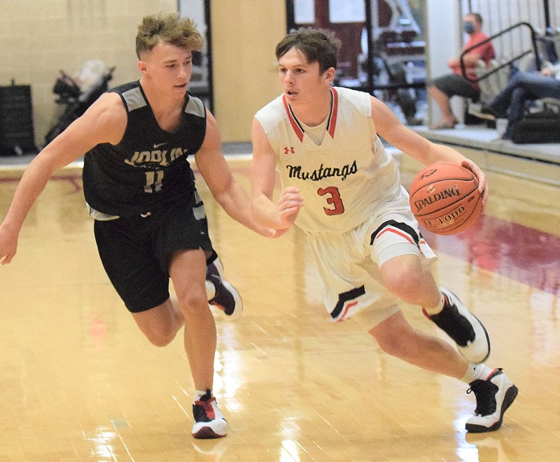 RICK PECK/SPECIAL TO MCDONALD COUNTY PRESS McDonald County's Pierce Harmon drives past Joplin's Dante Washington during a scrimmage held on Nov. 19 at Joplin High School.