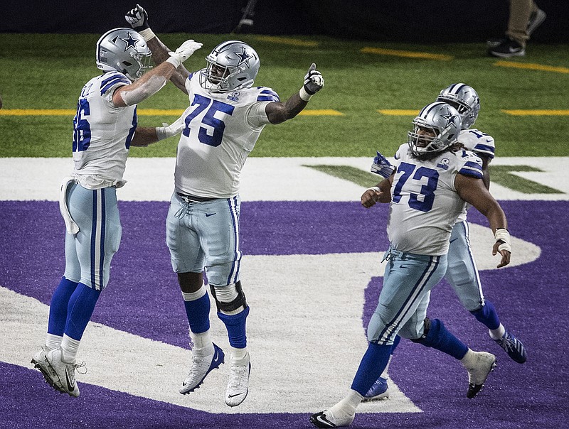 Dallas Cowboys offensive tackle Cameron Erving (75) celebrates tight end Dalton Schultz's (86) winning touchdown catch in the fourth quarter of an NFL football game against the Minnesota Vikings in Minneapolis, Sunday, Nov. 22, 2020. (Jerry Holt/Star Tribune via AP)