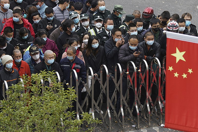 Airport workers wearing face masks to help curb the spread of the coronavirus wait for COVID-19 testing at the Shanghai Pudong International Airport in Shanghai, Monday, Nov. 23, 2020. Chinese authorities are testing millions of people, imposing lockdowns and shutting down schools after multiple locally transmitted coronavirus cases were discovered in three cities across the country last week. (AP Photo)