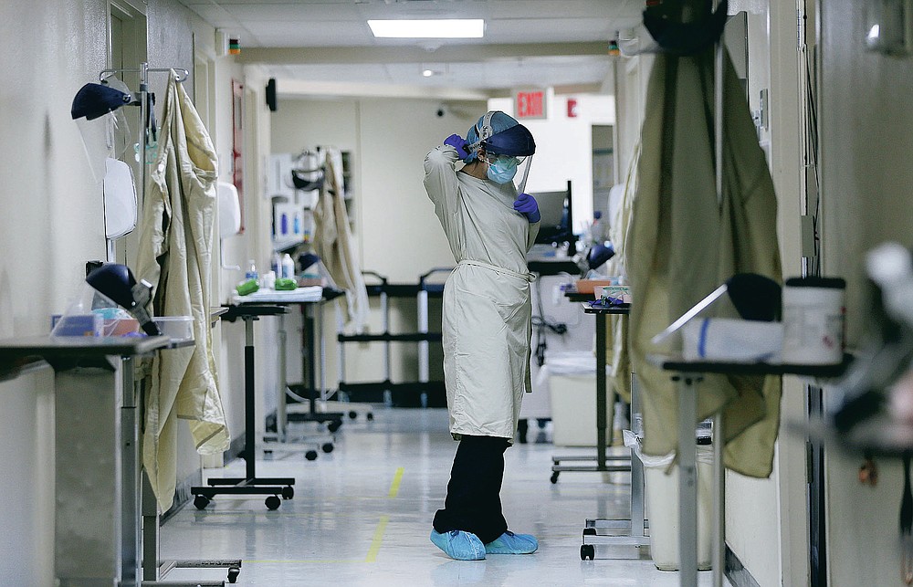Certified Nursing Assistant Angelica Corral constantly changes her personal protective equipment (PPE) as she travels from room to room at the El Paso Long Term Acute Care hospital, Friday, Nov. 6, 2020, in central El Paso, Texas. Across the city, more than 1,000 people per day are testing positive and the city’s major hospitals are overrun with severely ill and dying El Pasoans. (Mark Lambie/The El Paso Times via AP)