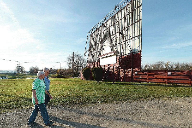 In this Nov. 7, 2020, photo, owners Margaret Koper and Dennis Koper walk at the Sunset Drive-In and Flea Market in Waterford Township, Pa. The couple has owned the drive-in since 1986. They didn't simply sit still waiting for COVID-19 to disappear and for crowds to return. Like many of the nation's other drive-ins, they sought out alternative programming. (Jack Hanrahan/Erie Times-News via AP)