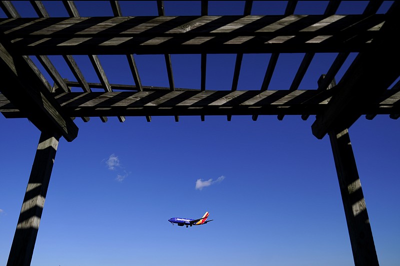 A shelter is seen at the Thomas Dixon Aircraft Observation Area as a Southwest Airlines flight from Jacksonville, Fla., makes its landing approach onto Baltimore-Washington International Thurgood Marshall Airport, Monday, Nov. 23, 2020, in Glen Burnie, Md.  With coronavirus cases spiking in the U.S. and Europe, the financial outlook of the world's airlines is getting worse. The International Air Transport Association said Tuesday that around the world, airlines will lose more than $157 billion this year and next. (AP Photo/Julio Cortez)