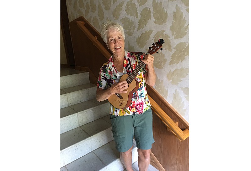 In this undated photo, Pat Adamson-Waitley, 62, stands with her ukulele at her home in Edina, Minn. Adamson-Waitley had played the ukulele a handful of times, but in March, she said, “I started playing it every day.” - Jane Adamson-Waitley via AP