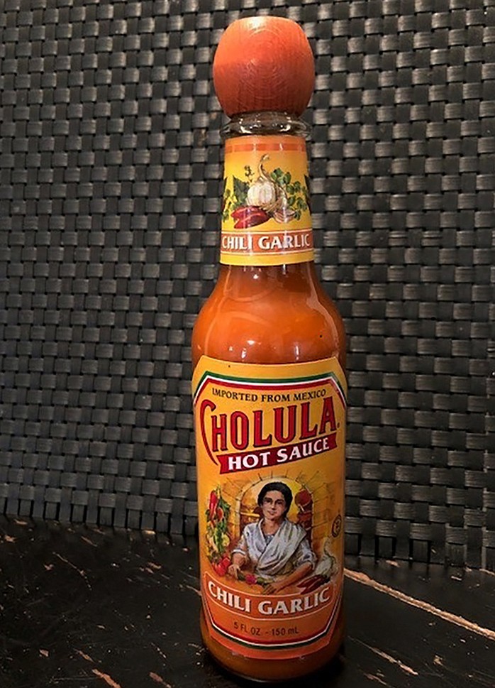 This Tuesday Nov. 24, 2020 photo shows a bottle of Cholula Hot Sauce. Spice maker McCormick & Co. is buying the parent of Cholula Hot Sauce from private-equity firm L Catteron for $800 million, expanding its reach in the hot sauce category.  That deal included French’s mustard and Frank’s RedHot brands. The company views the addition of Cholula as a way to appeal to millennials, a group that has a particular liking for the hot sauce.  (AP Photo/Charles Sheehan)