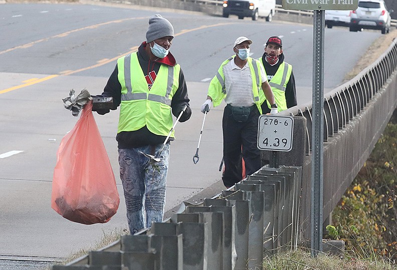 Hope Works program participants, from left, Anthony Walker, Steven Clayton and Tim Miller pick up trash along Malvern Avenue Tuesday. - Photo by Richard Rasmussen of The Sentinel-Record