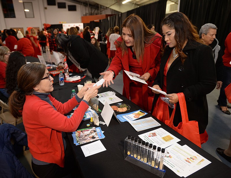 NWA Democrat-Gazette/ANDY SHUPE
Marelisa Colberg (left) a nutritionist with the Arkansas Department of Health, offers dietary information Saturday, Oct. 26, 2019, to attendees during the American Heart Association’s NWA Vestido Rojo event at the Springdale Civic Center. The event provides awareness of the increased risk of heart disease for Hispanic women and offer education and health screenings.