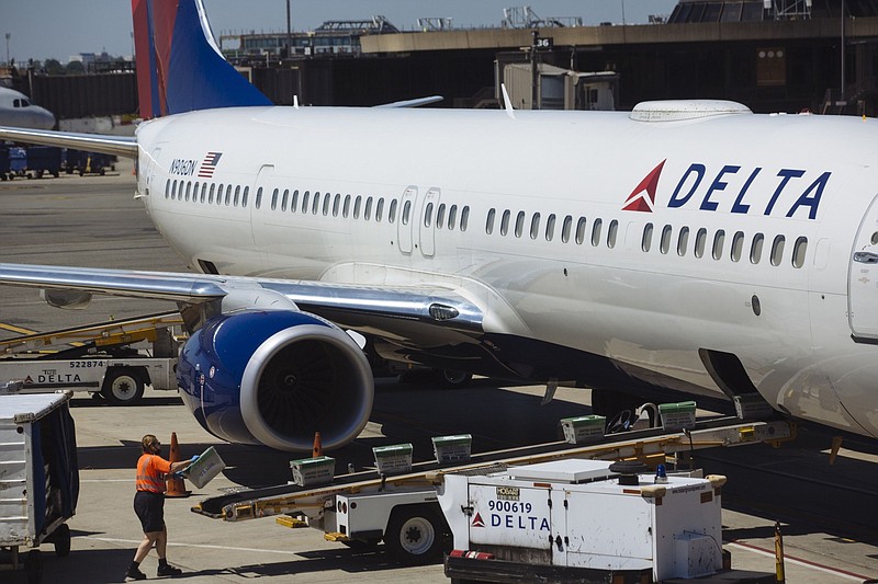 A worker loads postal packages onto a Delta Air lines jet parked at Newark International Airport in Newark, N.J., on June 9, 2020. 
(Bloomberg photo/Angus Mordant)