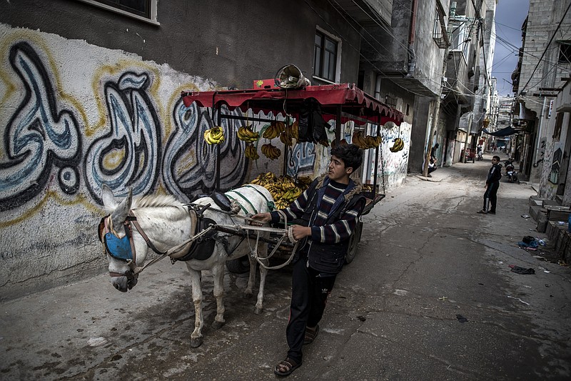 A Palestinian boy sells bananas on a donkey carte in an alley in the Shati refugee camp, in Gaza City, Wednesday. Israel's blockade of the Hamas-ruled Gaza Strip has cost the seaside territory as much as $16.7 billion in economic losses and caused its poverty and unemployment rates to skyrocket, a U.N. report said Wednesday, as it called on Israel to lift the 13-year closure. - AP Photo/Khalil Hamra