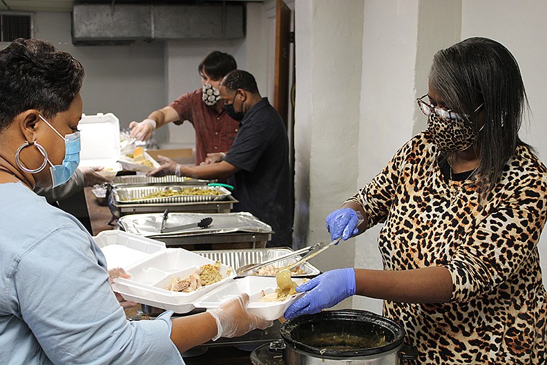 Volunteers fill plates at A Thanksgiving To Share at Visitors Chapel AME Church on Thursday, Nov. 26, 2020. It was the 16th year that The Giving Team Inc. hosted the event. - File photo by Tanner Newton of The Sentinel-Record