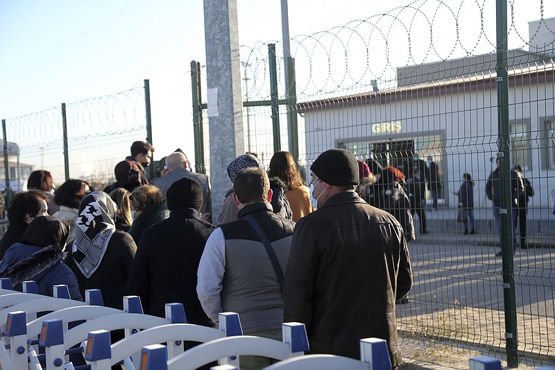 People wait outside a courthouse before the trial of 475 defendants, including generals and fighter jet pilots, in Sincan, Ankara, Turkey, Thursday, Nov. 26, 2020. A Turkish court sentenced several military and civilian personnel at an air base to life prison sentences on Thursday, proclaiming them guilty of involvement in a failed coup attempt in 2016, the state-run news agency reported. (AP Photo)