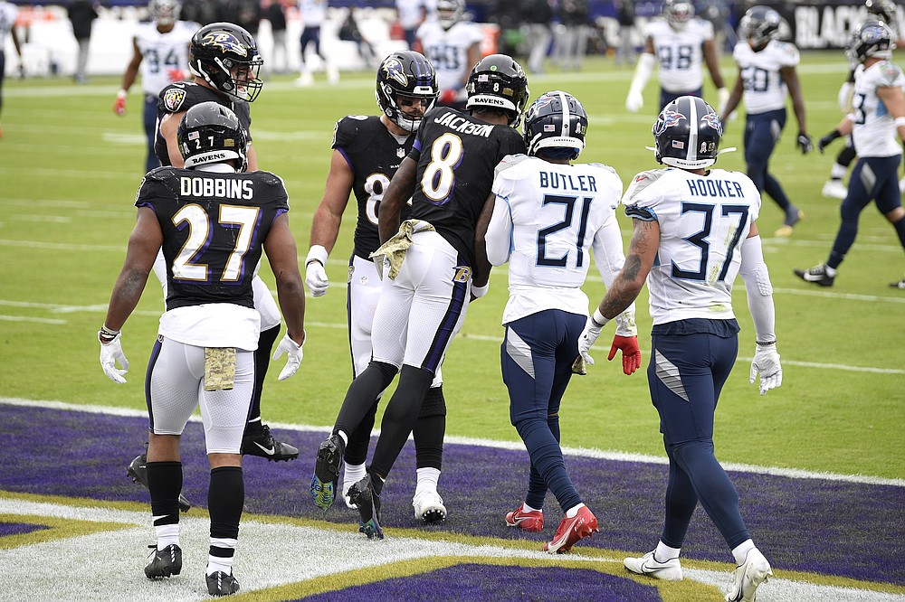 Baltimore Ravens quarterback Lamar Jackson (8) bumps Tennessee Titans cornerback Malcolm Butler (21) as the Ravens celebrate a touchdown catch by Mark Andrews, center left, during the second half of an NFL football game, Sunday, Nov. 22, 2020, in Baltimore. (AP Photo/Nick Wass)