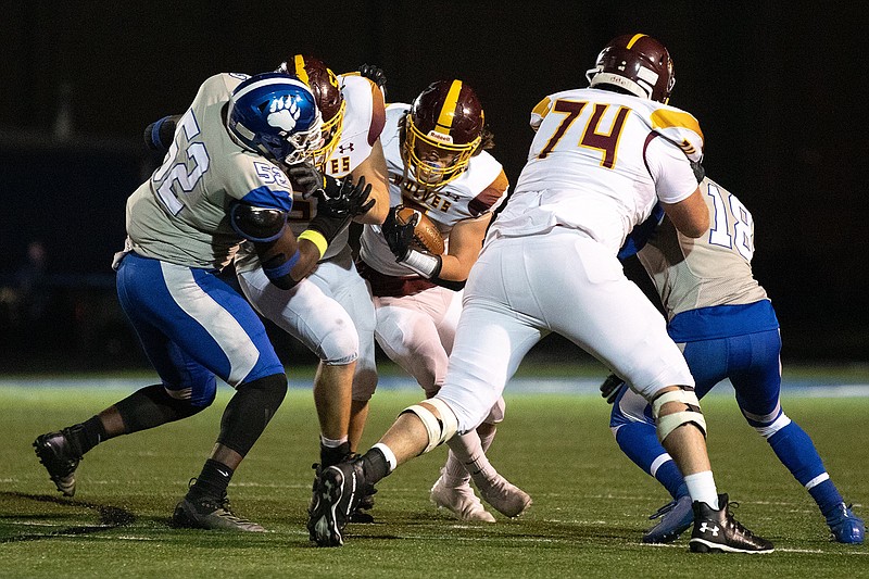 Lake Hamilton defensive tackle Bradley Rieman, center left, guards running back Owen Miller, center, from Sylvan Hills defensive end Jayden Rogers, far left, Friday night at Sylvan Hills Field in Sherwood. - Photo by Justin Cunningham of Arkansas Democrat-Gazette