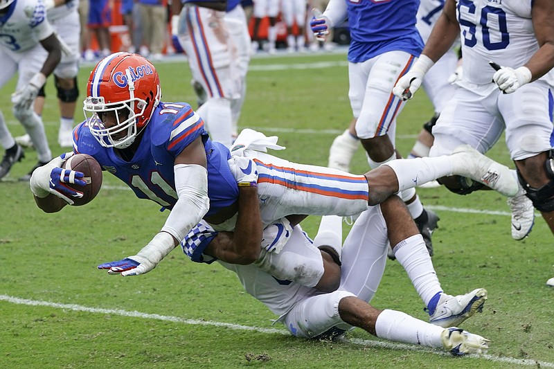 After intercepting a pass, Florida linebacker Mohamoud Diabate (11) dives for extra yardage over Kentucky tight end Keaton Upshaw during the second half of an NCAA college football game, Saturday, Nov. 28, 2020, in Gainesville, Fla. (AP Photo/John Raoux)