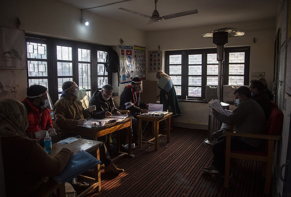 A Kashmiris casts her vote during the first phase of District Development Councils election on the outskirts of Srinagar, Indian controlled Kashmir, Saturday, Nov. 28, 2020. Thousands of people in Indian-controlled Kashmir voted Saturday amid tight security and freezing cold temperatures in the first phase of local elections, the first since New Delhi revoked the disputed region's semiautonomous status. (AP Photo/Mukhtar Khan)