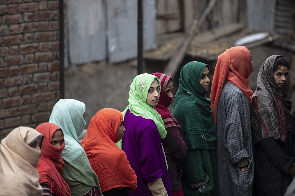 Kashmiris stand in a queue to cast their votes during the first phase of District Development Councils election on the outskirts of Srinagar, Indian controlled Kashmir, Saturday, Nov. 28, 2020. Thousands of people in Indian-controlled Kashmir voted Saturday amid tight security and freezing cold temperatures in the first phase of local elections, the first since New Delhi revoked the disputed region's semiautonomous status. (AP Photo/Mukhtar Khan)